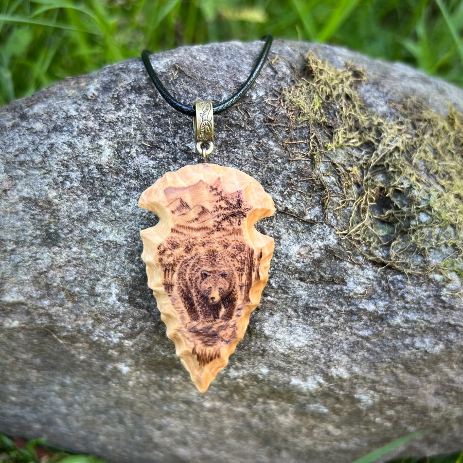 Wood-carved arrowhead with bear pyrography