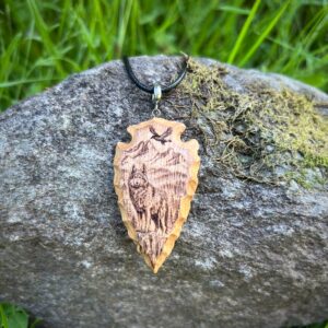 wood-carved arrowhead with wolf pyrography