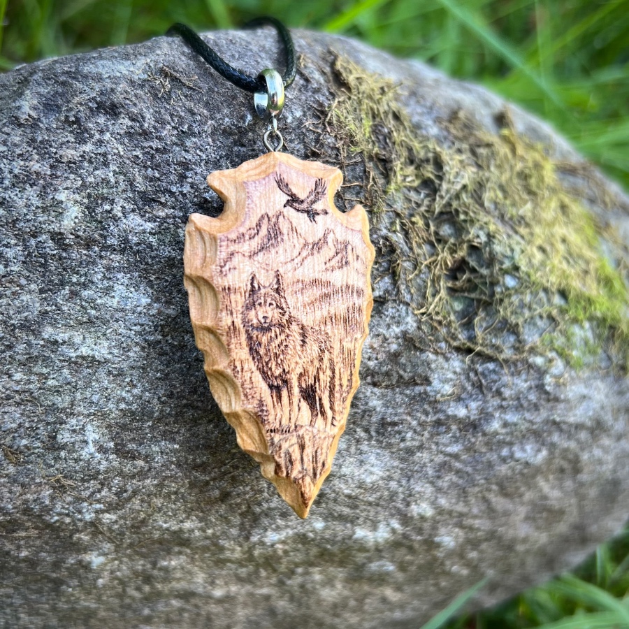 wood-carved arrowhead with wolf pyrography