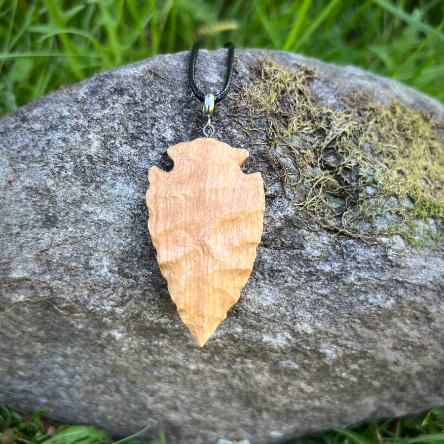 wood-carved arrowhead with wolf pyrography