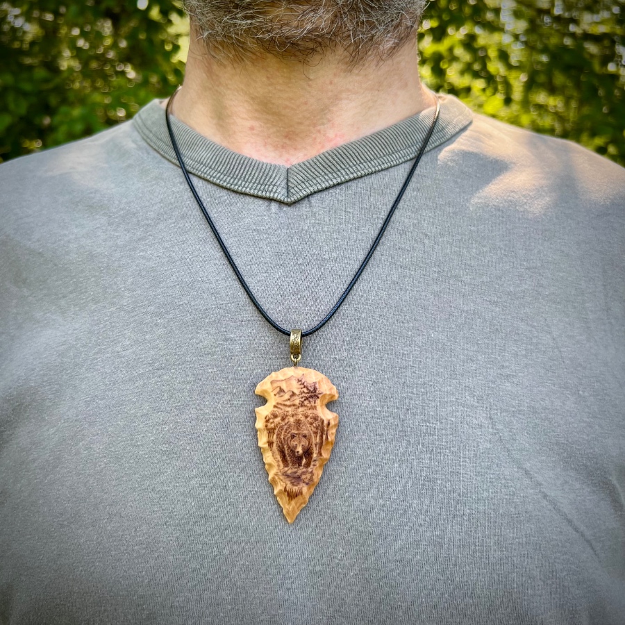 wood-carved arrowhead with bear pyrography