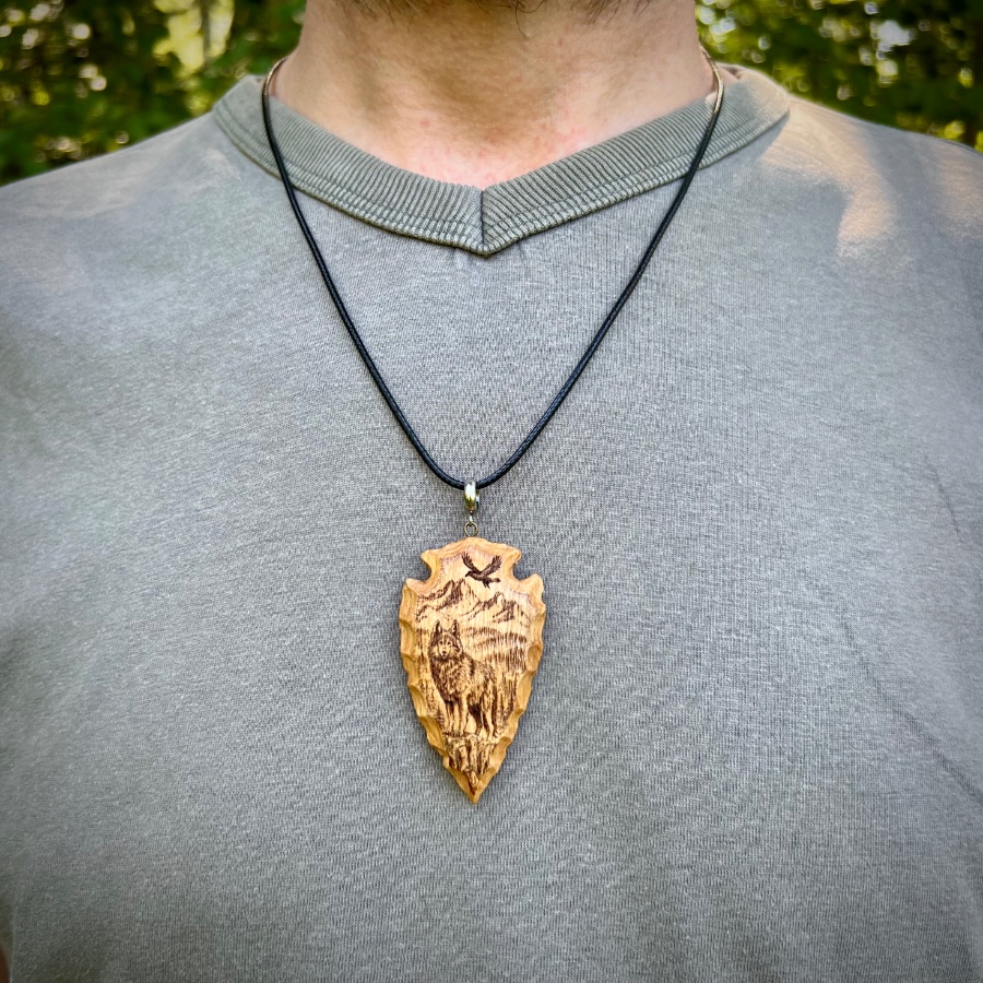 wood-carved arrowhead with wolf pyrography