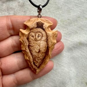 wood-carved arrowhead pendant featuring a barn owl