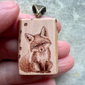 small apple wooden pendant with the image of a cute baby fox on it