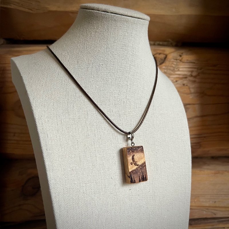 Wooden pendant on a bust, to show how it will hang when wearing it.