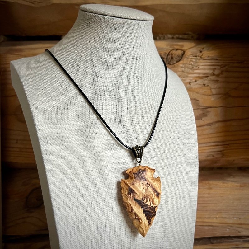 Wooden pendant on a bust, to show how it will hang when wearing it.